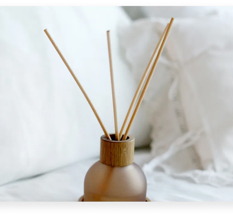 Cozy unmade bed with rumpled linens, bird art on wall, and bedside lamp