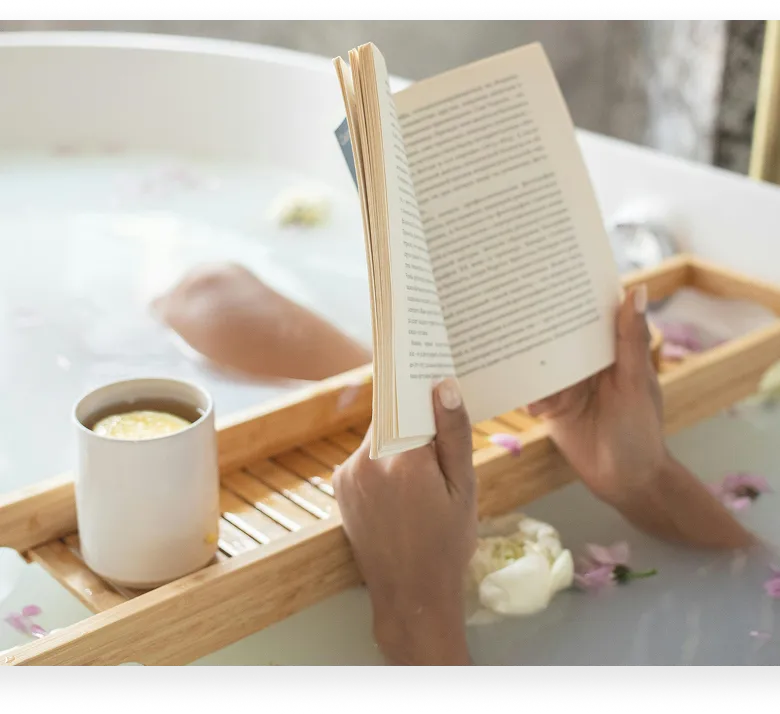 Cozy unmade bed with rumpled linens, bird art on wall, and bedside lamp