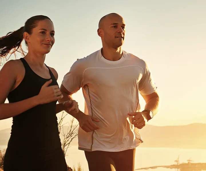 Two people jogging at sunset in nature