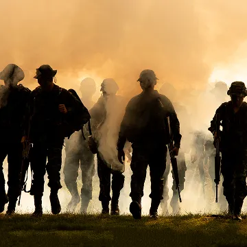 a group of soldiers marching through a grassy field