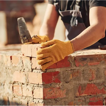a man is consructing a brick wall
