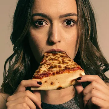 person holding a slice of cheese pizza
