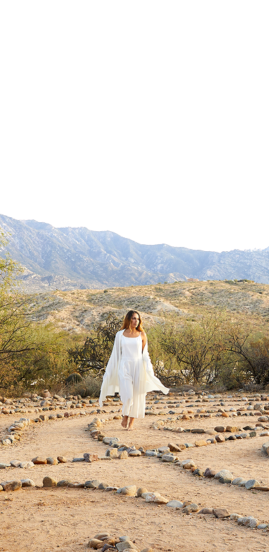 woman practicing mindfulness in desert labyrinth with mountains