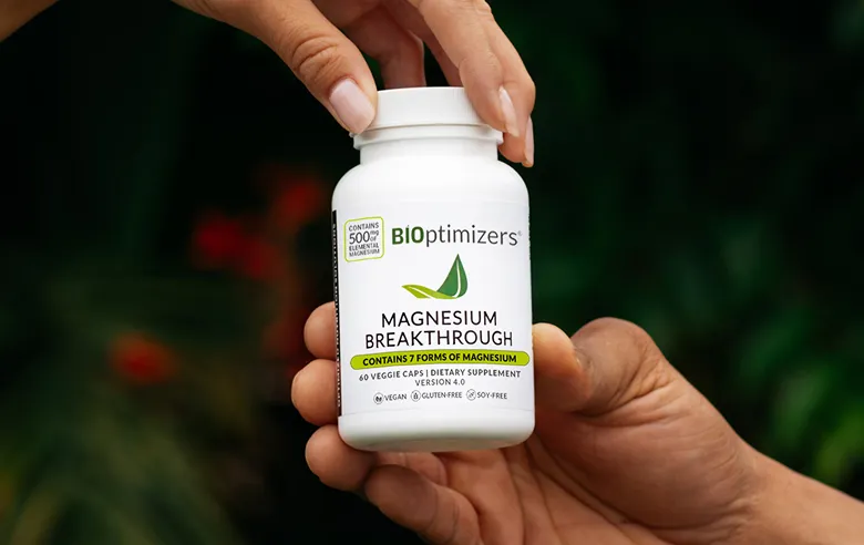 Hands holding a bottle of BIOptimizers Magnesium Breakthrough
