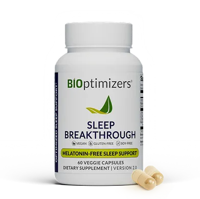 Hand holding a white sleep supplement capsule with a moon and Zzz icon symbolizing nighttime rest