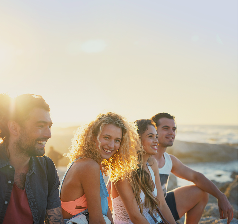 Couple sitting on desert rocks at sunset with mountain and cactus landscape in the background