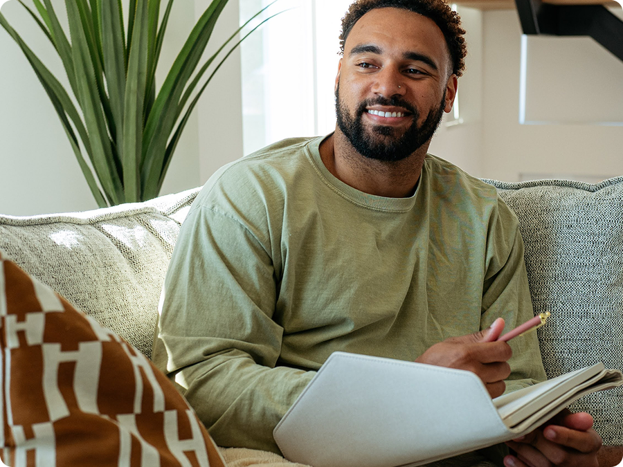 Man journaling on a couch